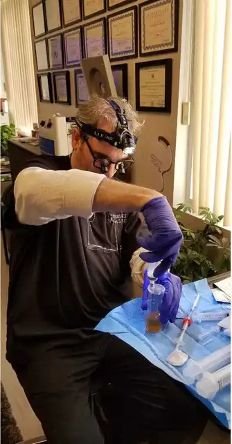 Thomas Pulice PA-C preparing PRP for Vampire Breast Lift treatment — Las Vegas Aesthetics, credentials wall visible
